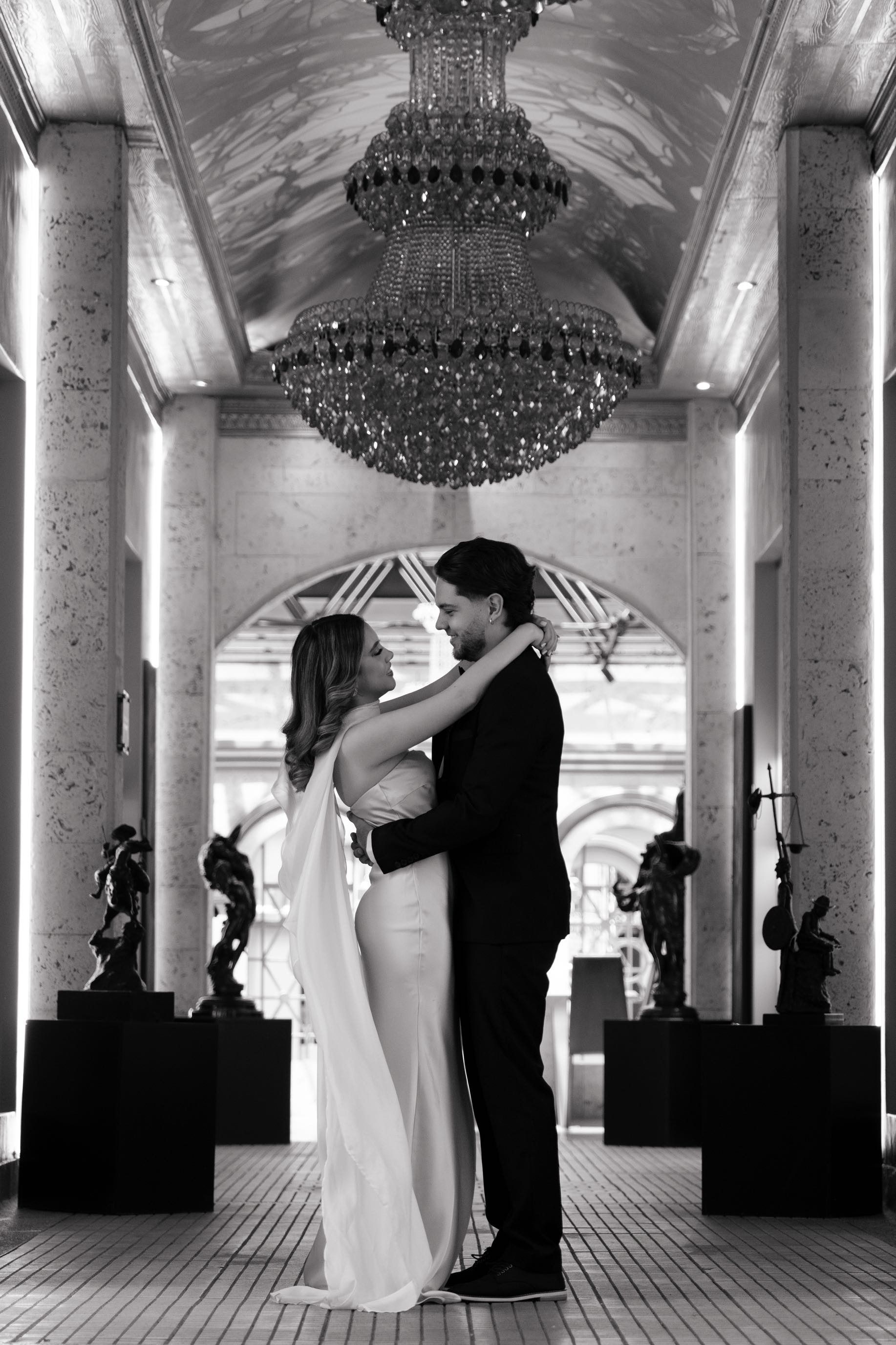 La pareja abrazada bajo el candelabro en blanco y negro